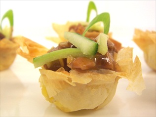 Duck with hoisin sauce in filo pastry baskets. Perfect canape for a light bite on the hoof